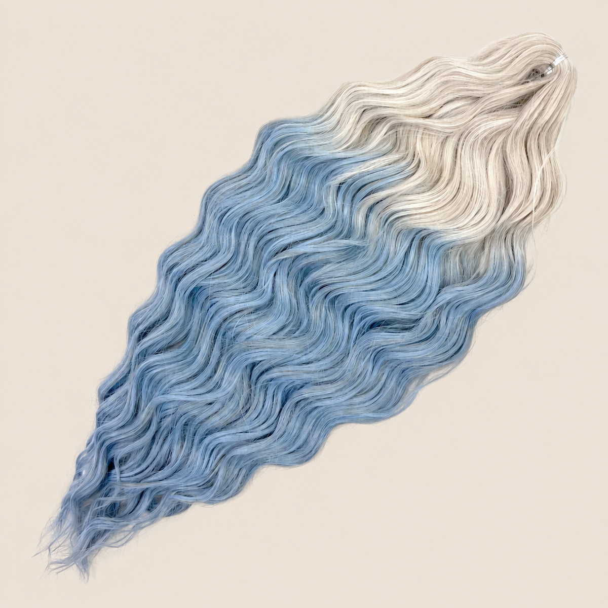Anna golvend kanekalon invlechthaar zilver-blauw ombre TT-56C/JSBLUE, 60 cm en 100 gram op beige achtergrond