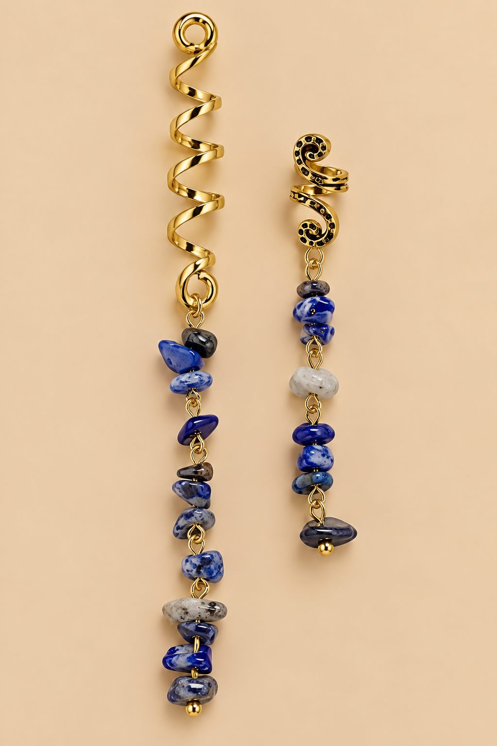 Set van twee goudkleurige boho haarspiralen met blauwe en grijze steentjes op beige achtergrond
