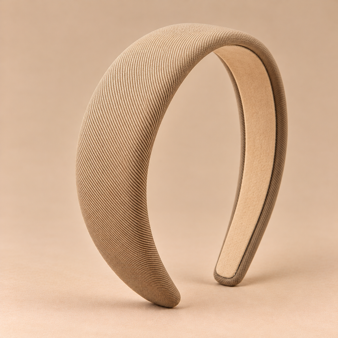 Beige khaki brede gewatteerde haarband op egale beige achtergrond