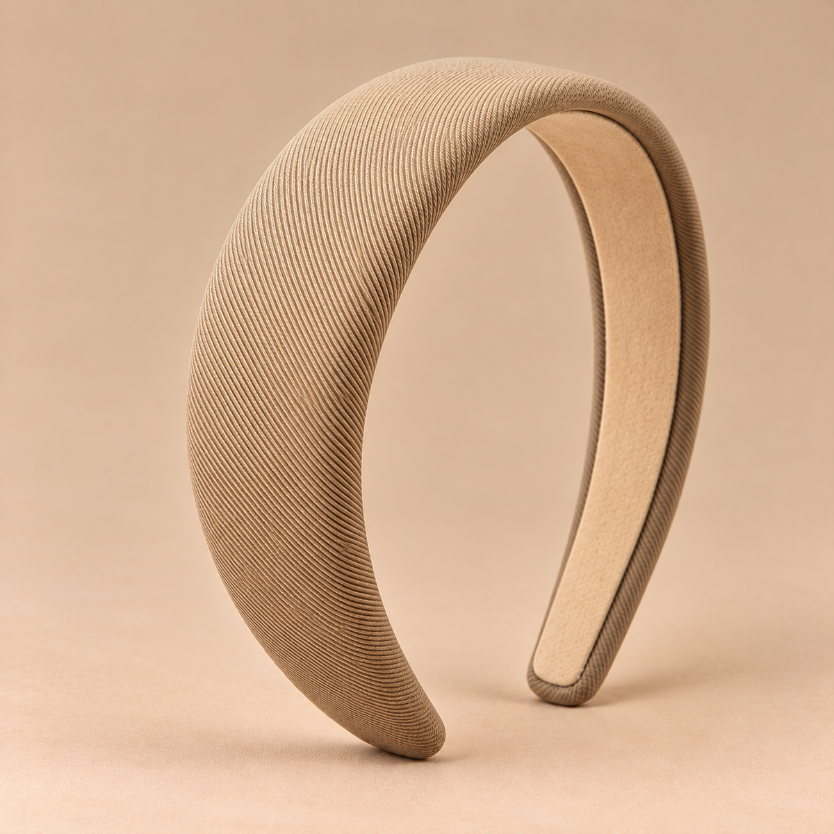 Beige khaki brede gewatteerde haarband op egale beige achtergrond