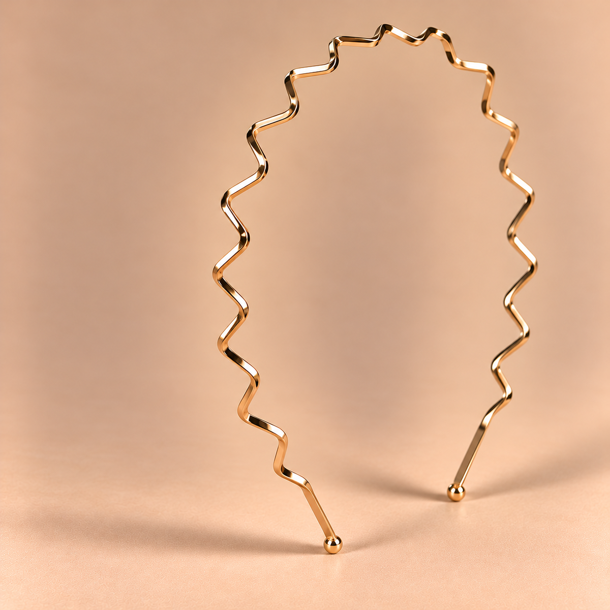 Gouden metalen haarband met zigzagpatroon op een luxe beige achtergrond