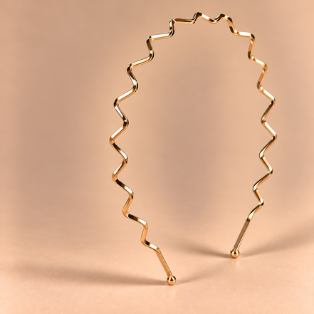 Gouden metalen haarband met zigzagpatroon op een luxe beige achtergrond