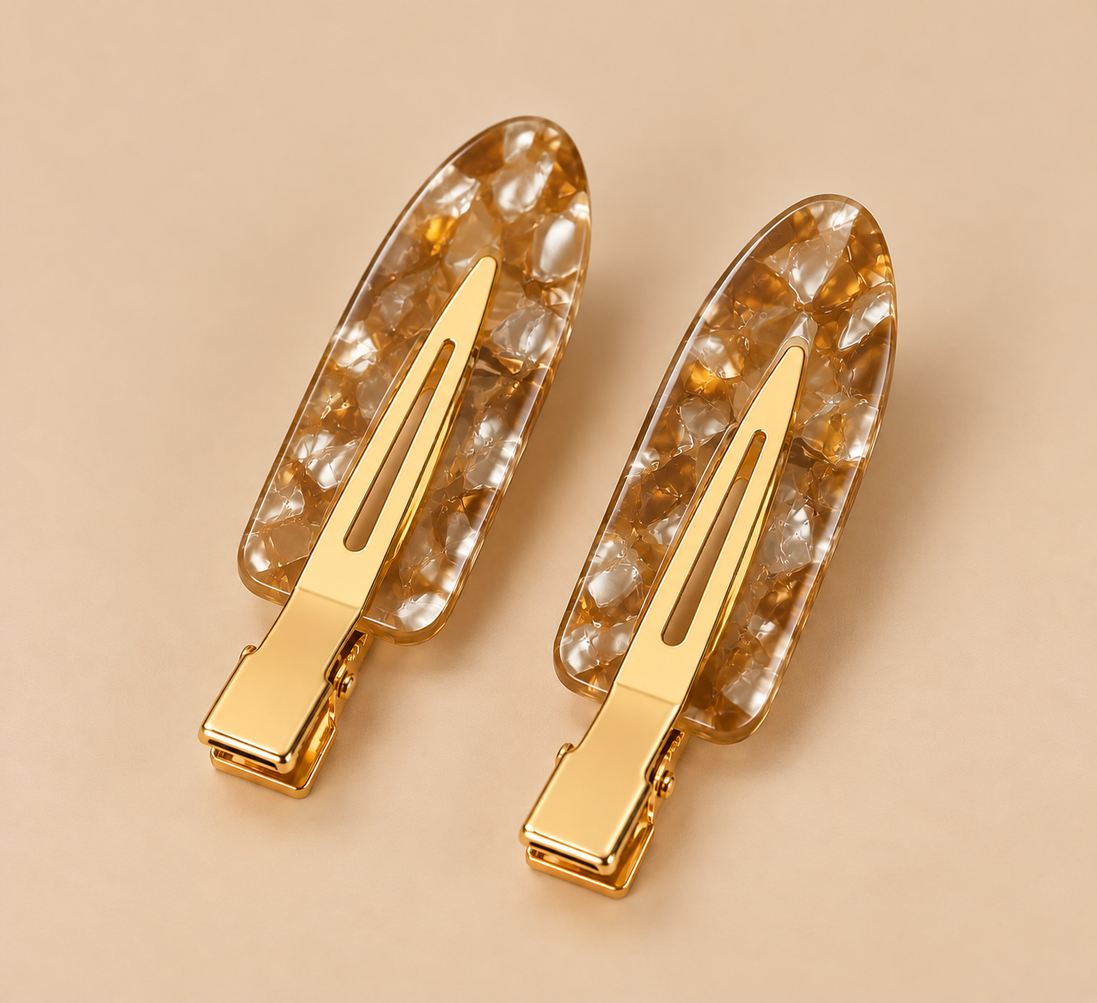 Set van twee amberbruine gemarmerde haarclips op beige achtergrond
