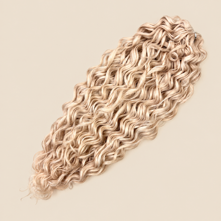 Jessica golvend invlechthaar 60 cm in blond (Creamy) op beige achtergrond – De HaarBoetiek