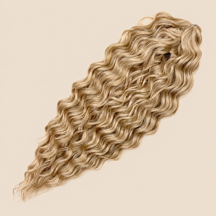 Kate golvend invlechthaar 60 cm in vlasblond (Linen(59)) op beige achtergrond