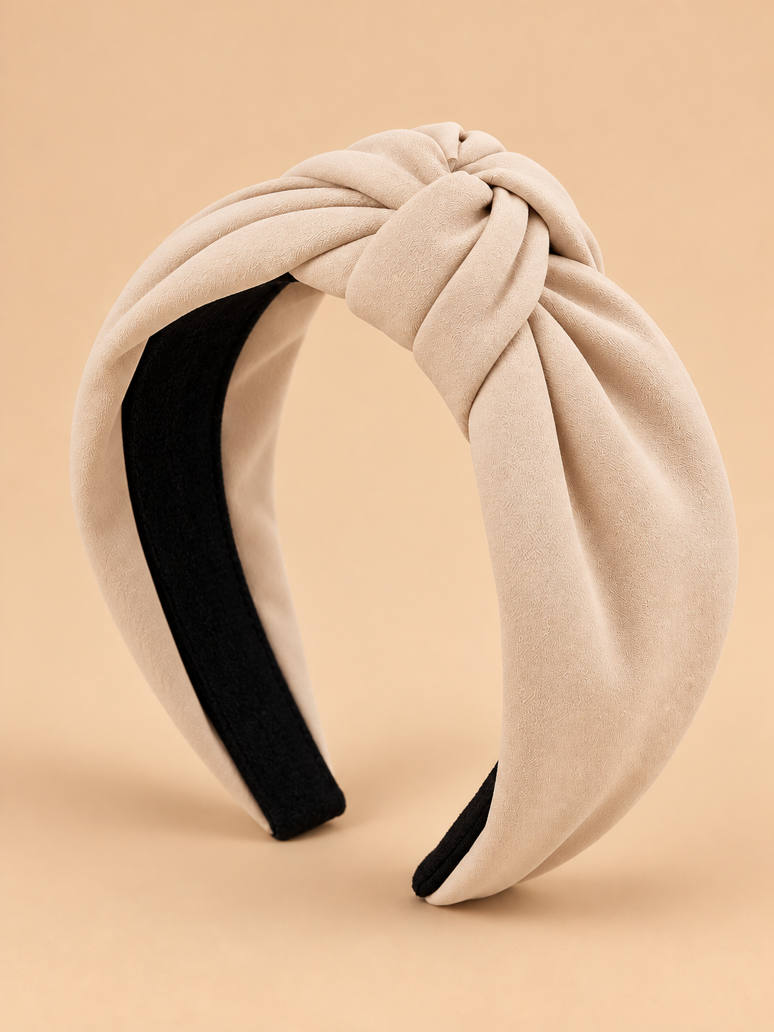 Beige knoop haarband op egale beige achtergrond