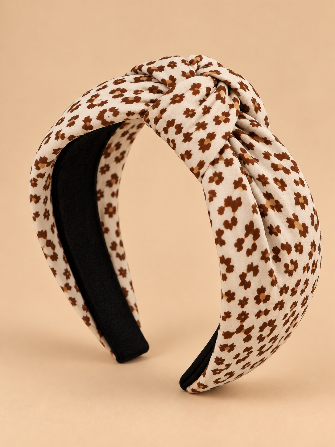 Crème bruine knoop haarband met dierenprint op egale beige achtergrond