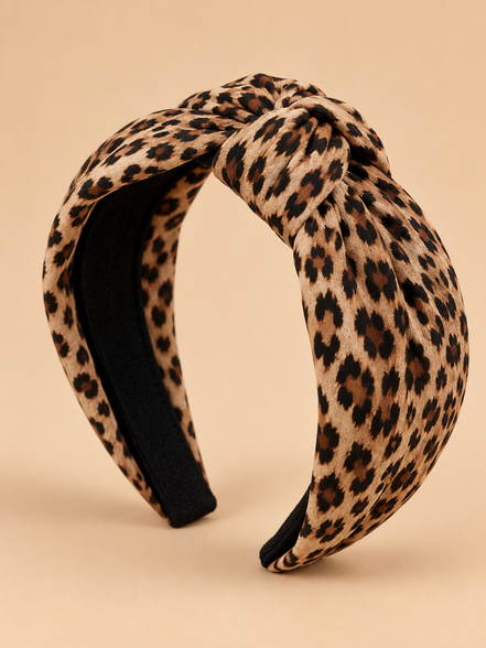 Knoop haarband met luipaardprint op egale beige achtergrond