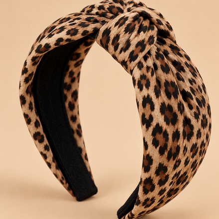 Knoop haarband met luipaardprint op egale beige achtergrond