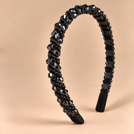 Smalle zwarte kristallen haarband op beige achtergrond