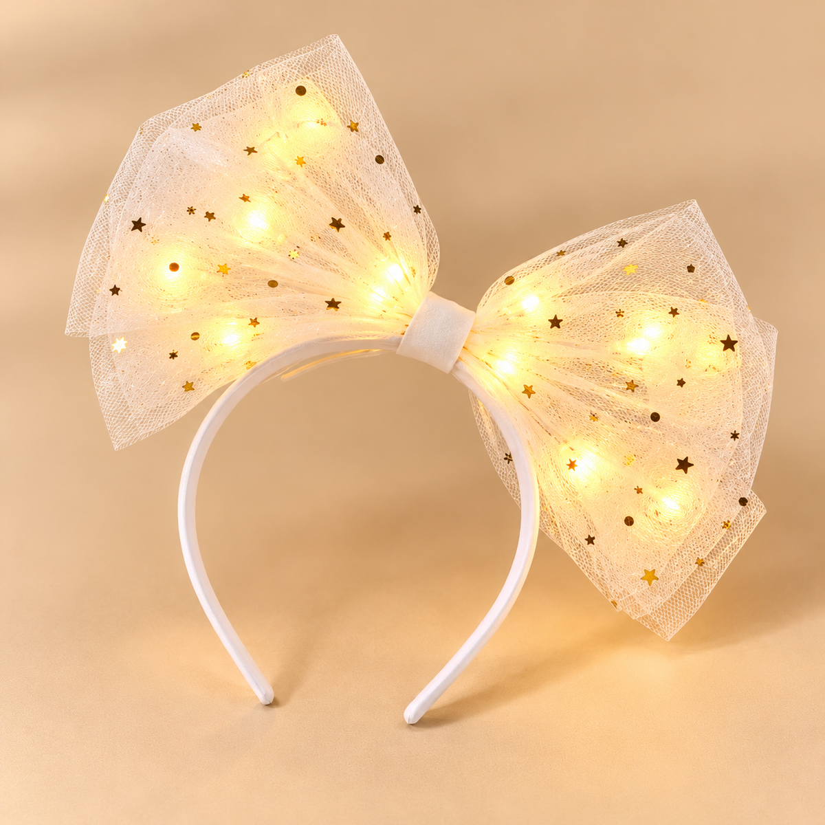 Witte diadeem met één tule strik en warmgouden lichtjes op beige achtergrond