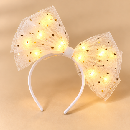 Witte diadeem met één tule strik en warmgouden lichtjes op beige achtergrond
