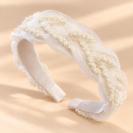 Witte gevlochten diadeem met pareldetails op een lichtbeige achtergrond