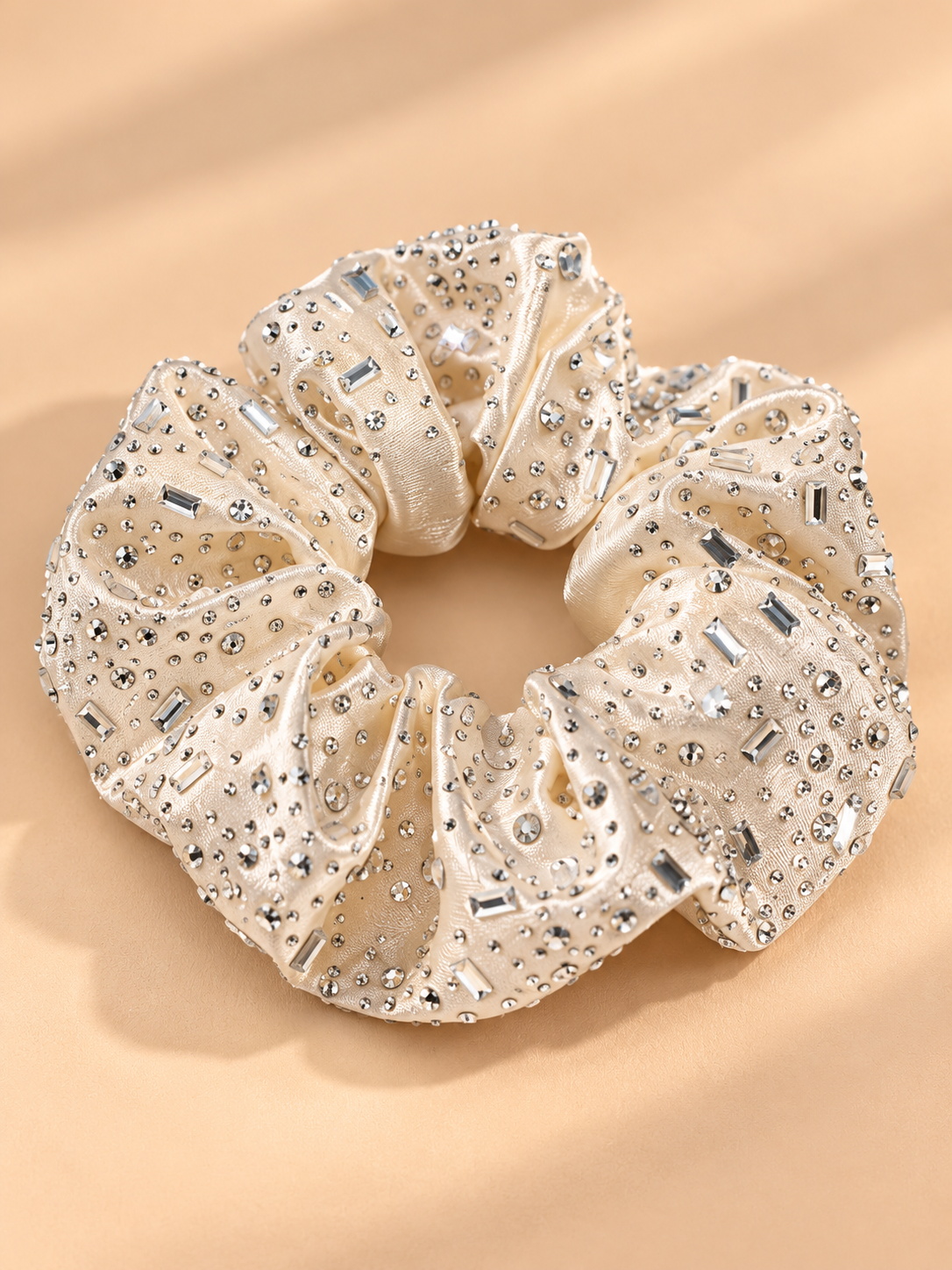 Luxe beige champagne scrunchie met strass steentjes op beige achtergrond