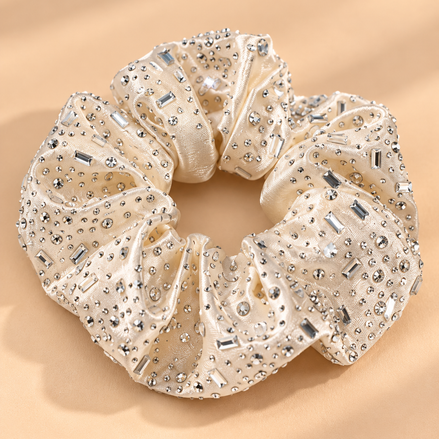 Luxe beige champagne scrunchie met strass steentjes op beige achtergrond