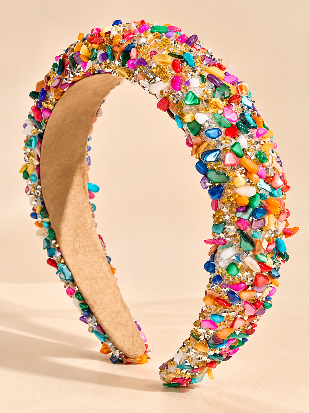 Brede multicolor haarband met gekleurde edelstenen en kristallen op beige achtergrond