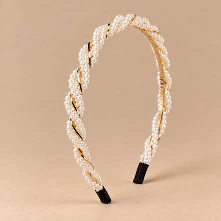 Gedraaide parelhaarband met ivoorkleurige imitatieparels en goudkleurige details op beige achtergrond