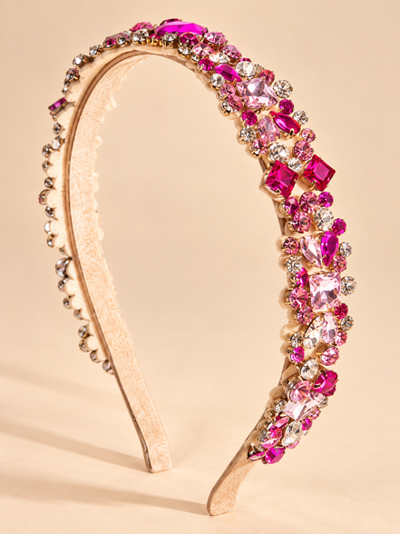 Luxe roze kristallen haarband met strass op beige achtergrond