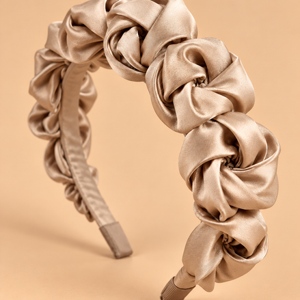 Champagne beige satijnen bloemen haarband op egale beige achtergrond