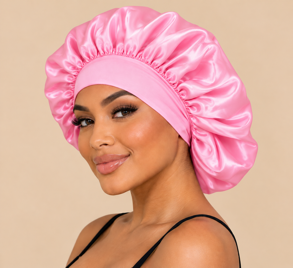 Roze satijnen slaapbonnet gedragen door model op beige achtergrond