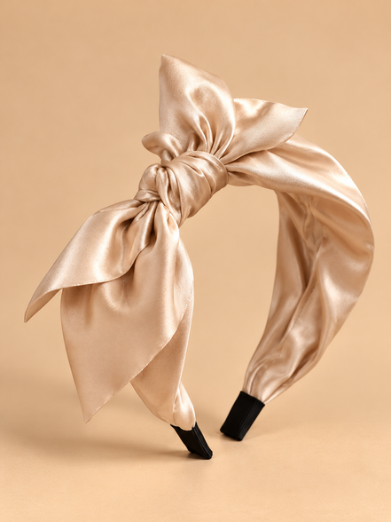 Champagne beige satijnen strik haarband op egale beige achtergrond