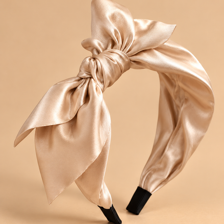 Champagne beige satijnen strik haarband op egale beige achtergrond
