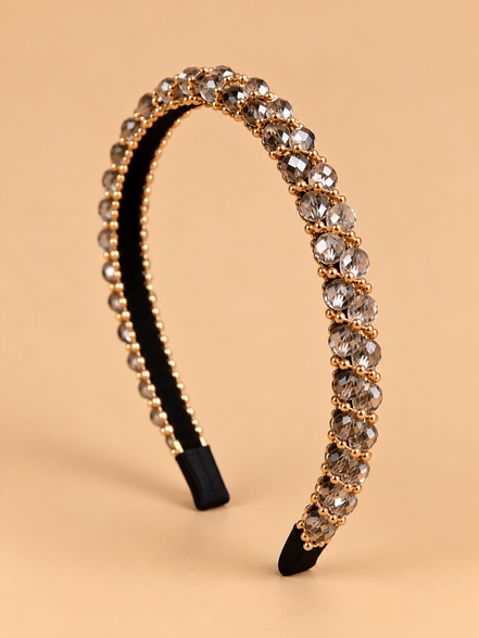 Smalle kristal haarband in smoky champagne met gouden details op beige achtergrond