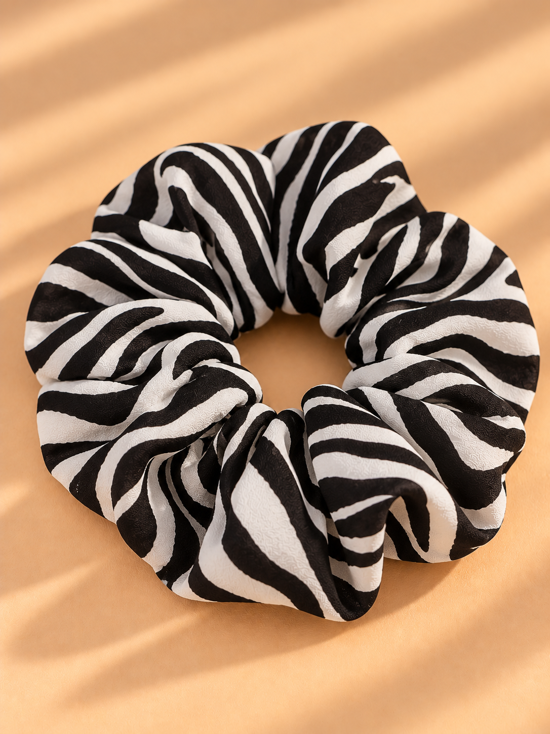 Zwart-witte zebra scrunchie op beige achtergrond