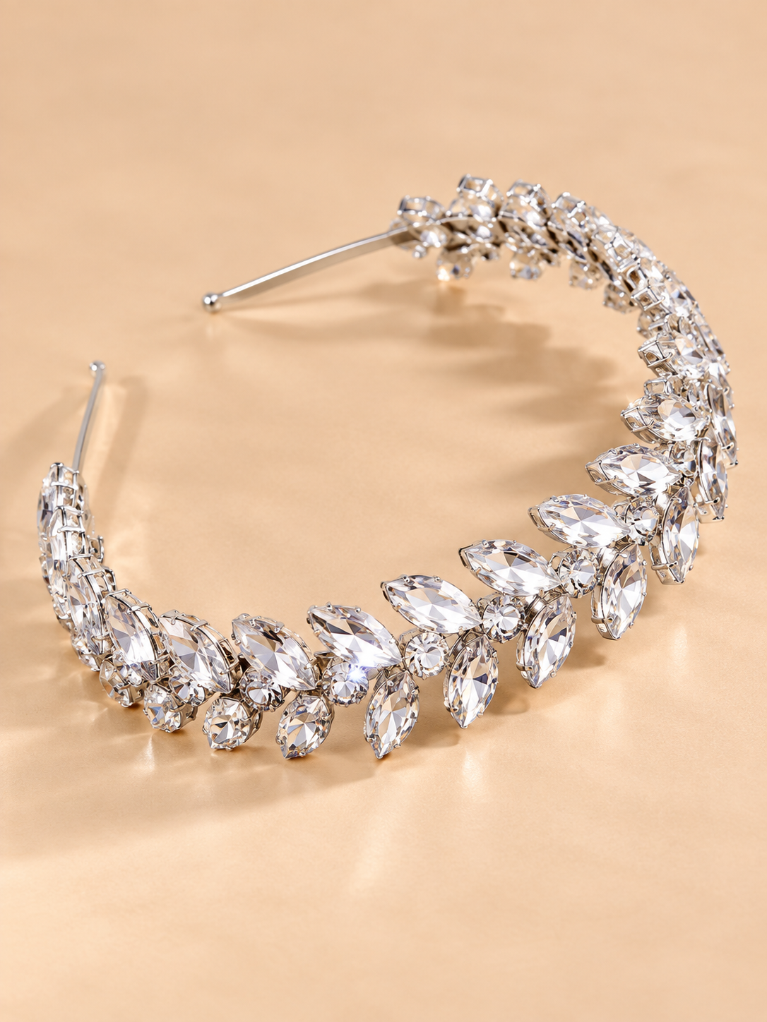 Luxe zilverkleurige kristallen blad diadeem op beige achtergrond
