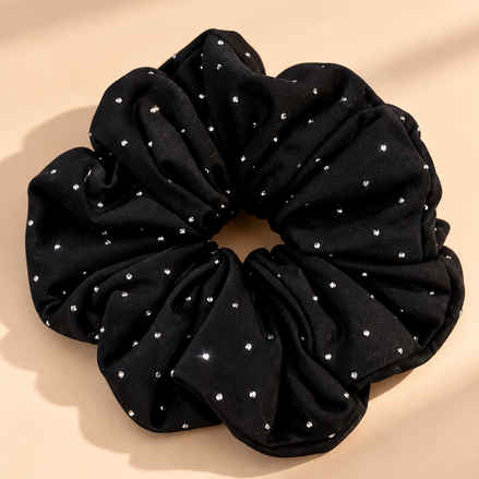 Luxe zwarte scrunchie met strass steentjes op beige achtergrond